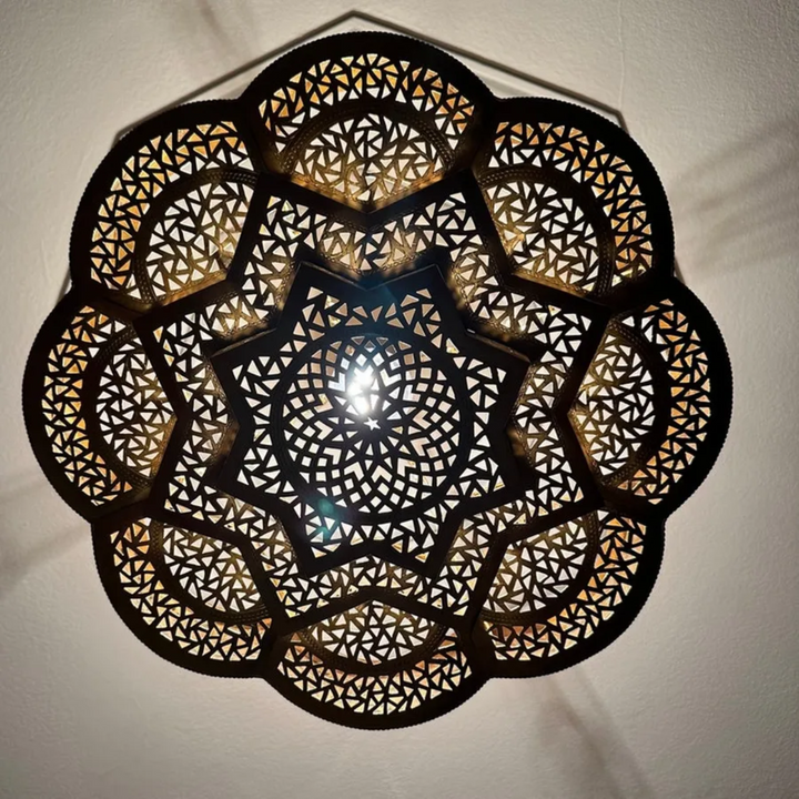 Close up of hand-carved floral brass details on pre-wired pendant fixture for high-end retail catalogs.