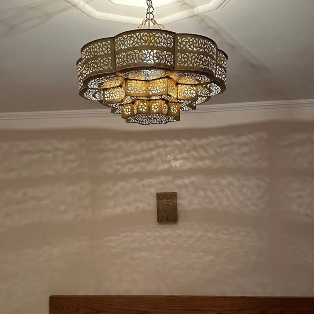 Close up of hand-carved floral perforations on solid brass sphere pendant fixture for architect sourcing.