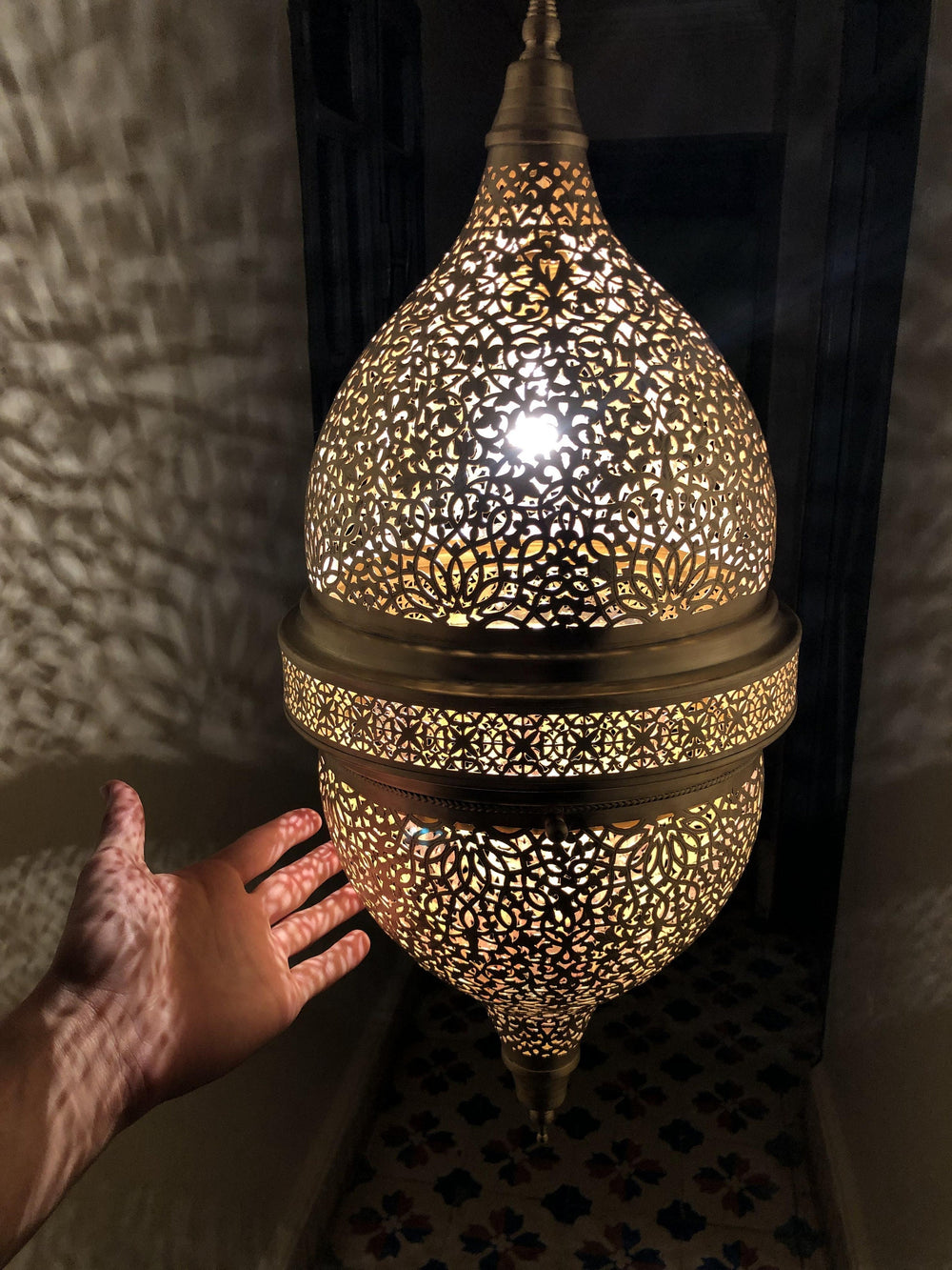 Handcrafted Moroccan brass pendant light casting geometric patterns, ideal for hotel and restaurant projects