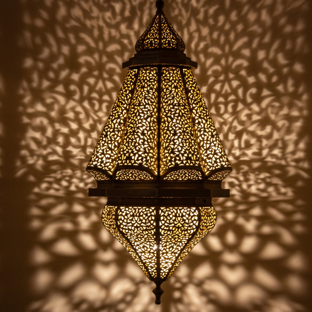 Amira brass ceiling light with graceful hanging shape and warm golden glow for dining rooms, bedrooms, and elegant interiors.