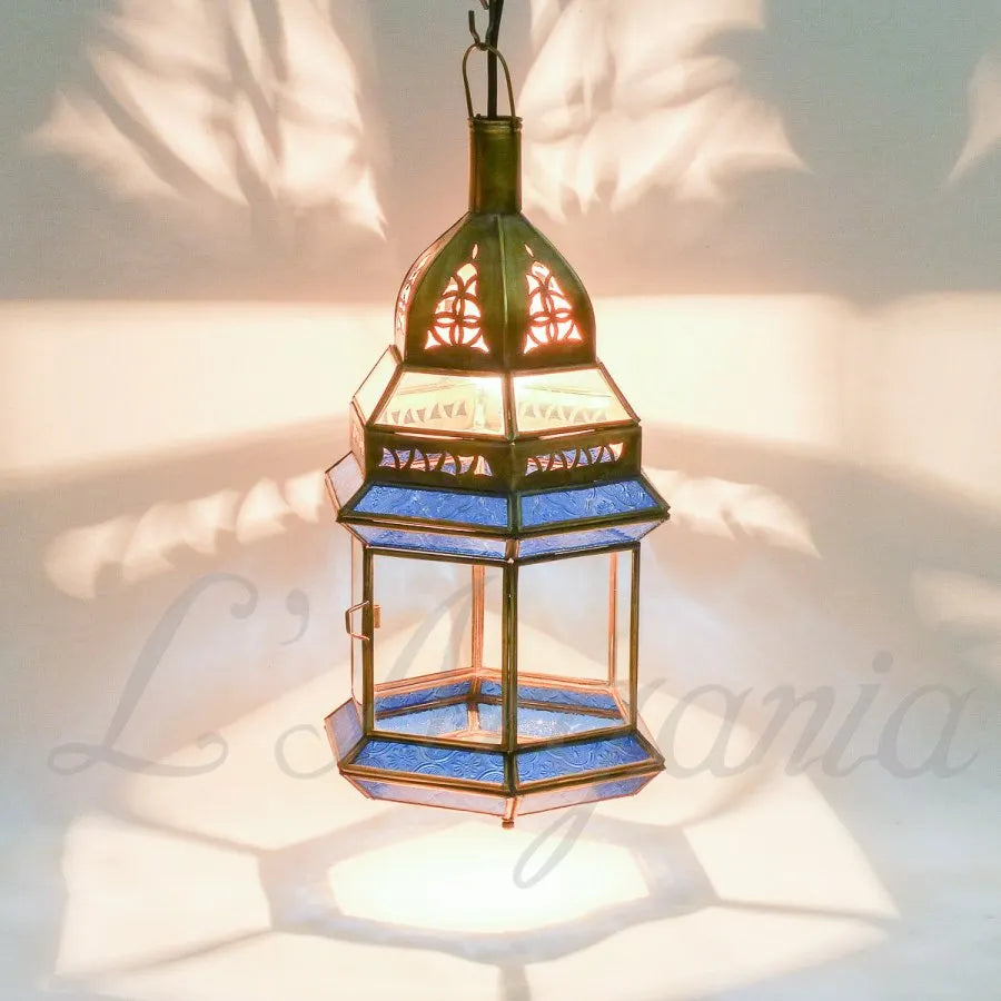Aziza Blue lantern with colored glass panels and brass frame styled for boutique patio lighting.