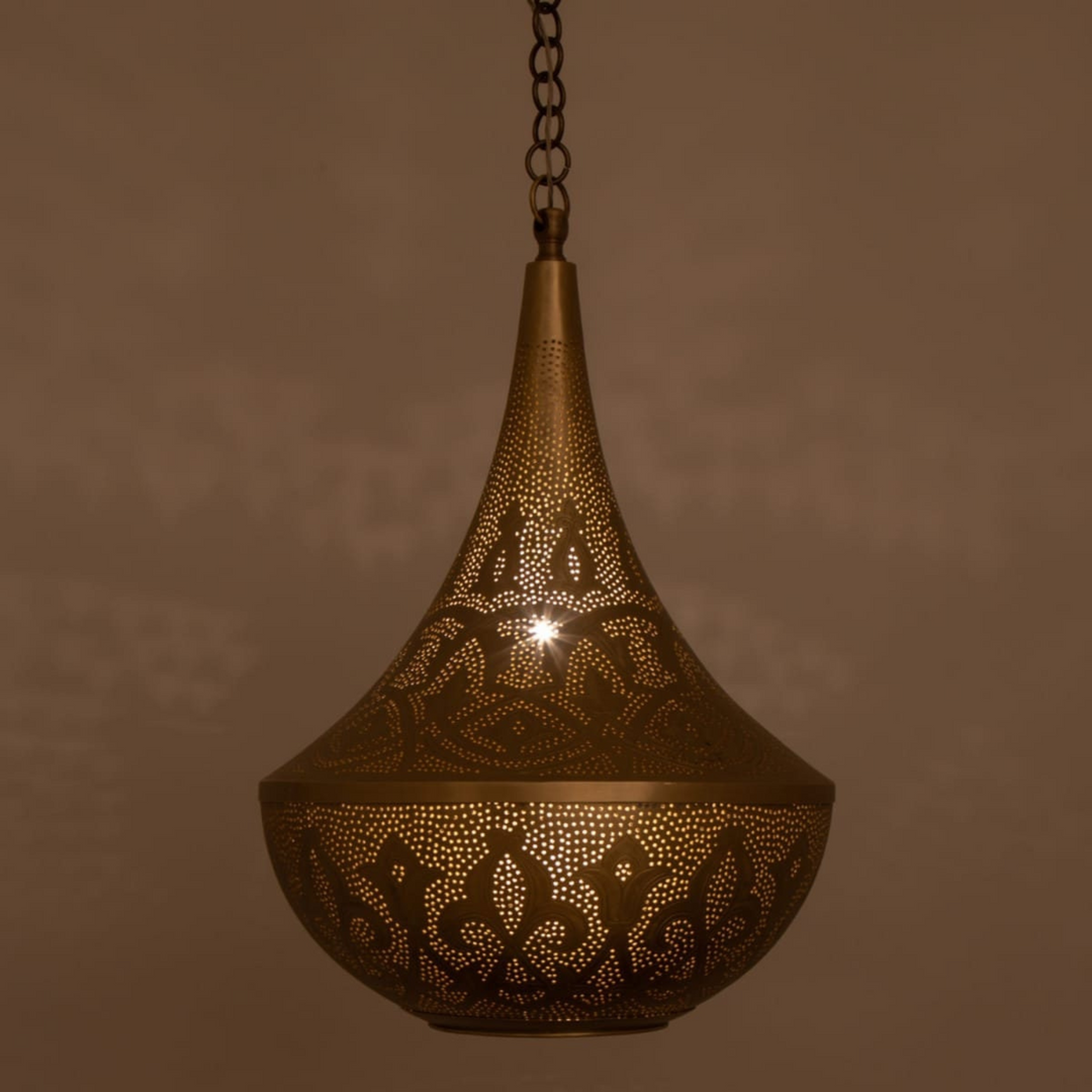 Yussra Moroccan pendant fixture in brass finish casting delicate shadows above tables, lounges, and quiet sitting corners.