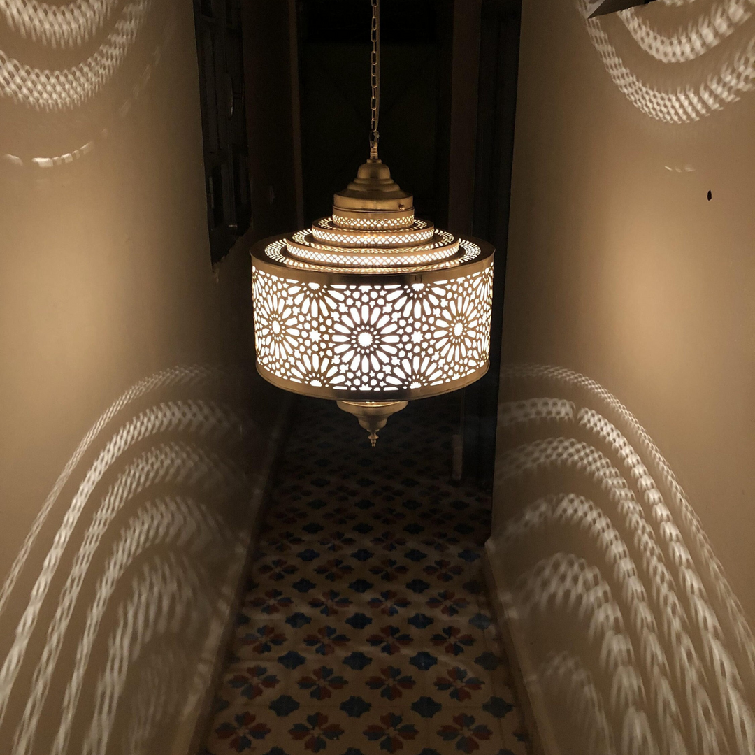 Ibrahim Parchment decorative overhead lamp adding soft golden warmth above a foyer, lounge corner, or guest room.