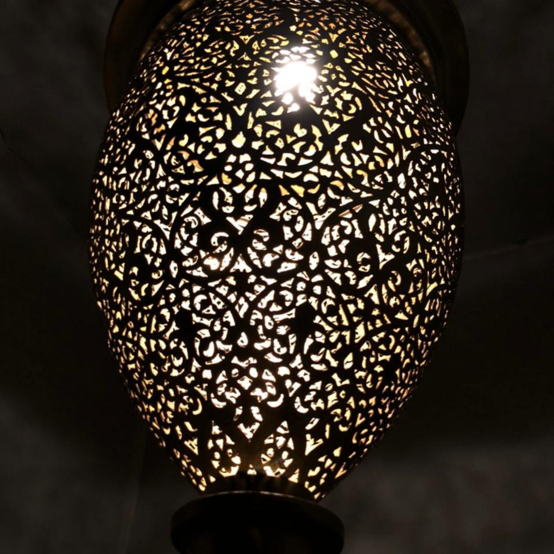 Close view of Hilal Moroccan brass light showing curved metal detail and carefully punched decorative openings.