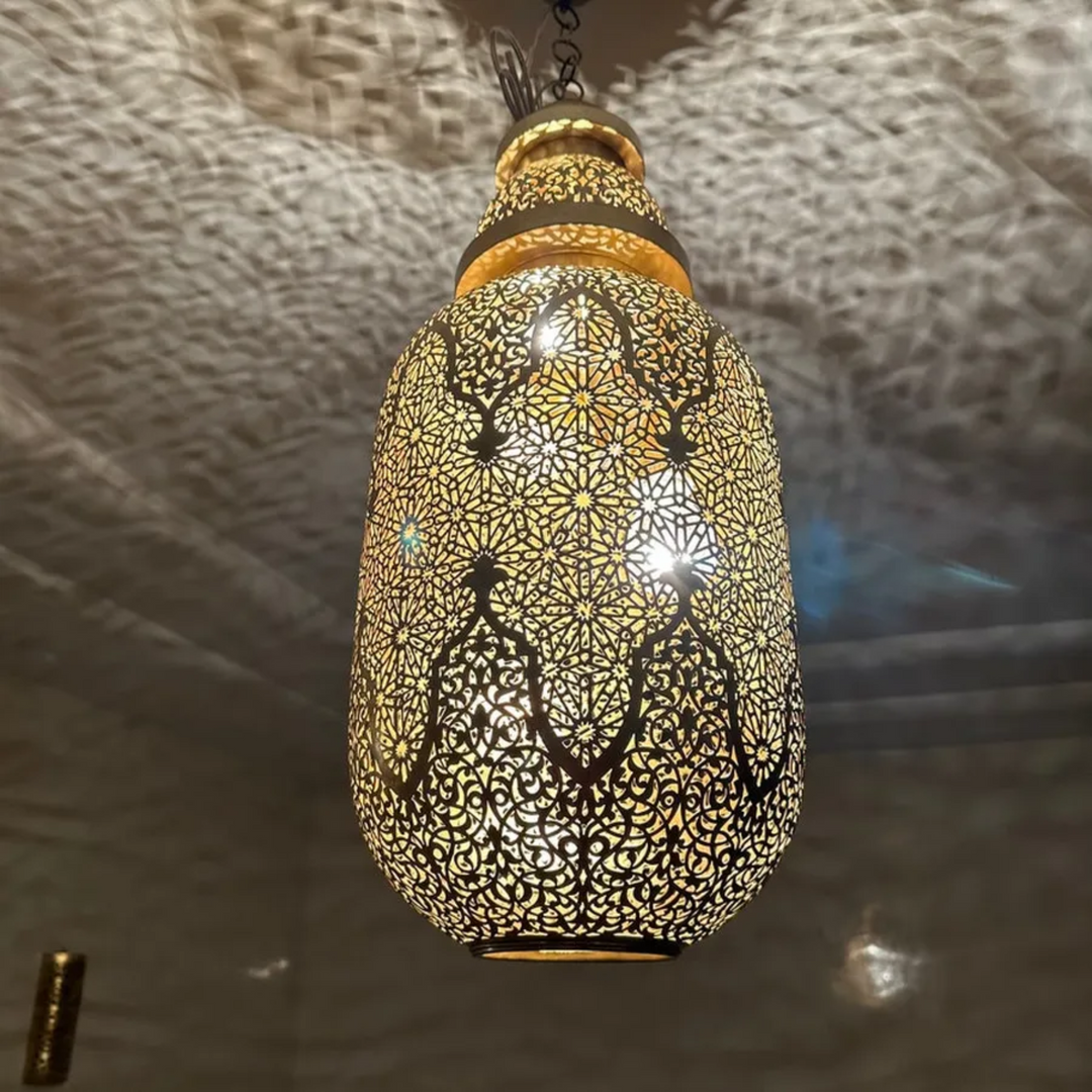 Jamila brass pendant lamp with Moroccan metal texture and golden tone for cozy bedroom lighting and refined ceiling decor.