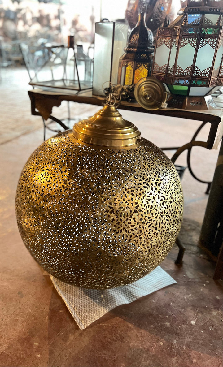 Side angle of Louz brass light showing rounded handmade form for boutique hotel interior decor.