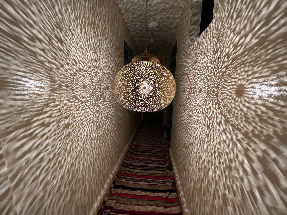 Angled view of Lubna ceiling fixture showing handcrafted brass form for restaurant lighting projects.