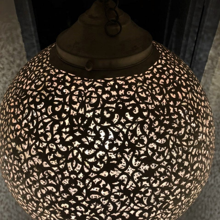Koora decorative overhead lamp adding golden warmth above a lounge corner, foyer, or peaceful guest bedroom.