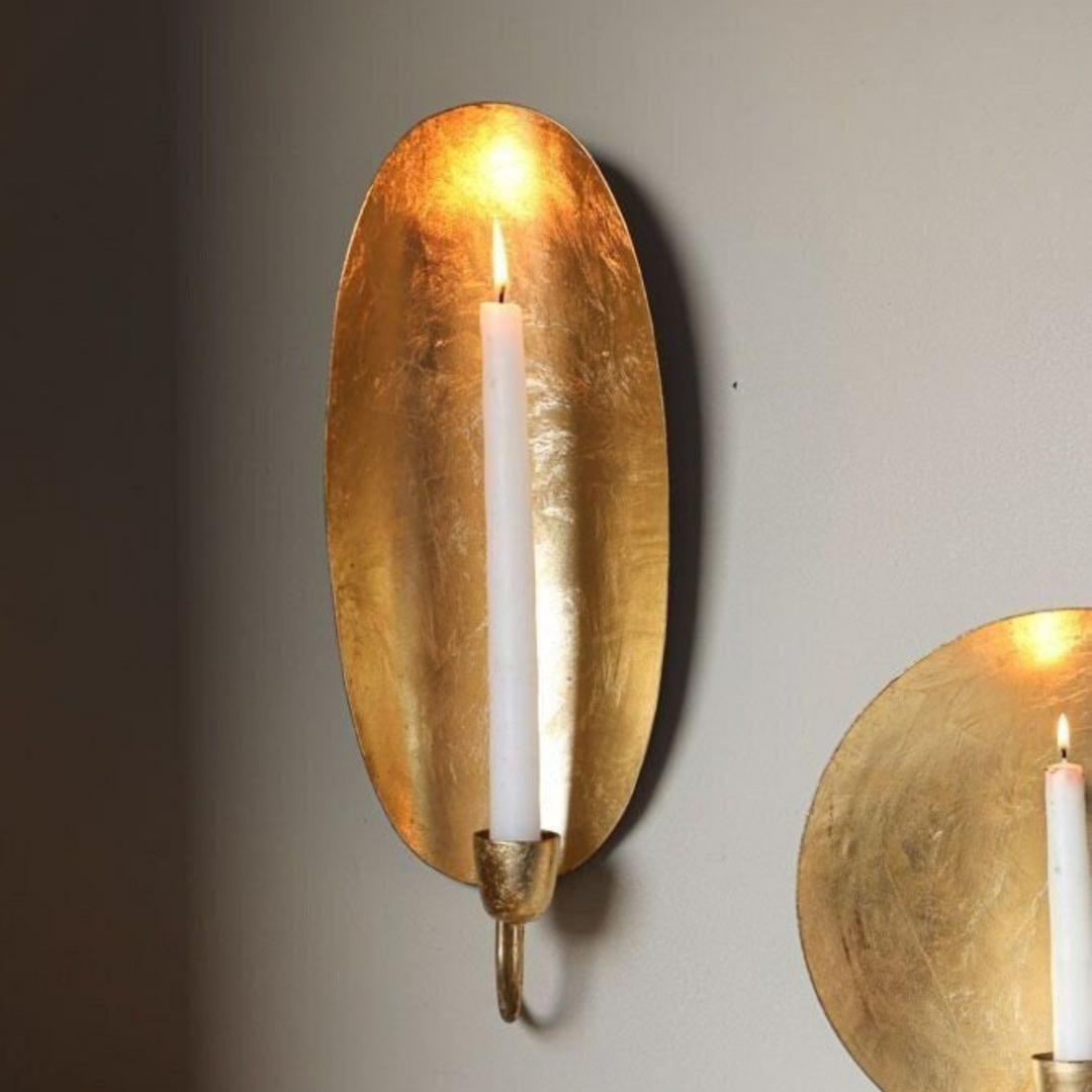 Brass Candle Holder Oval placed on a shelf with Moroccan charm, reflective brass tone, and soft decorative candlelight