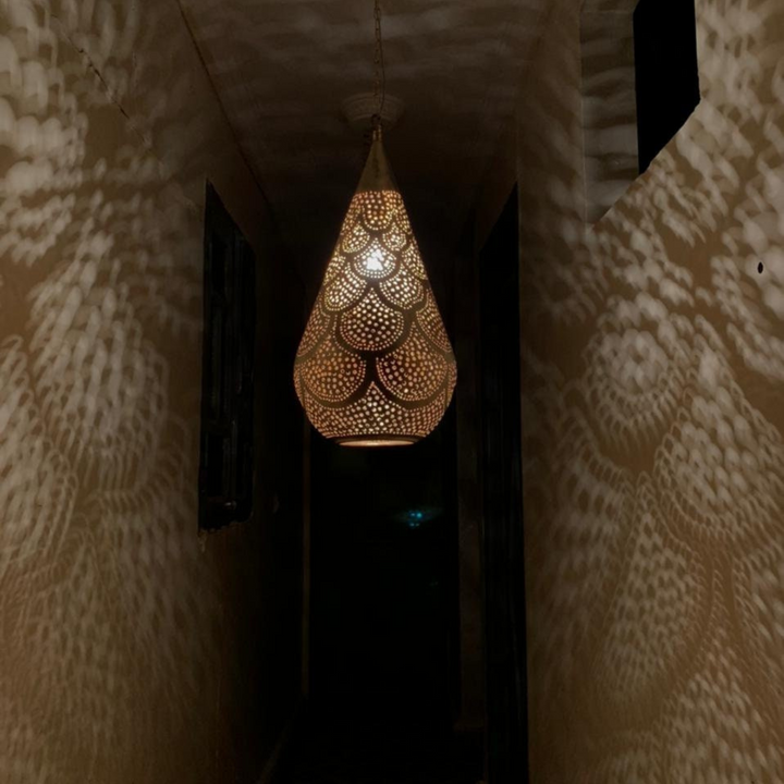 Angled Tear Waves ceiling fixture highlighting curved brass waves, tapered body, and decorative pierced pattern.